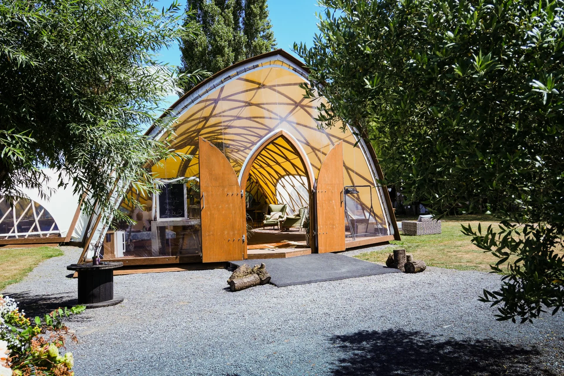 Het Strohboid paviljoen met open houten deuren, omringd door groen