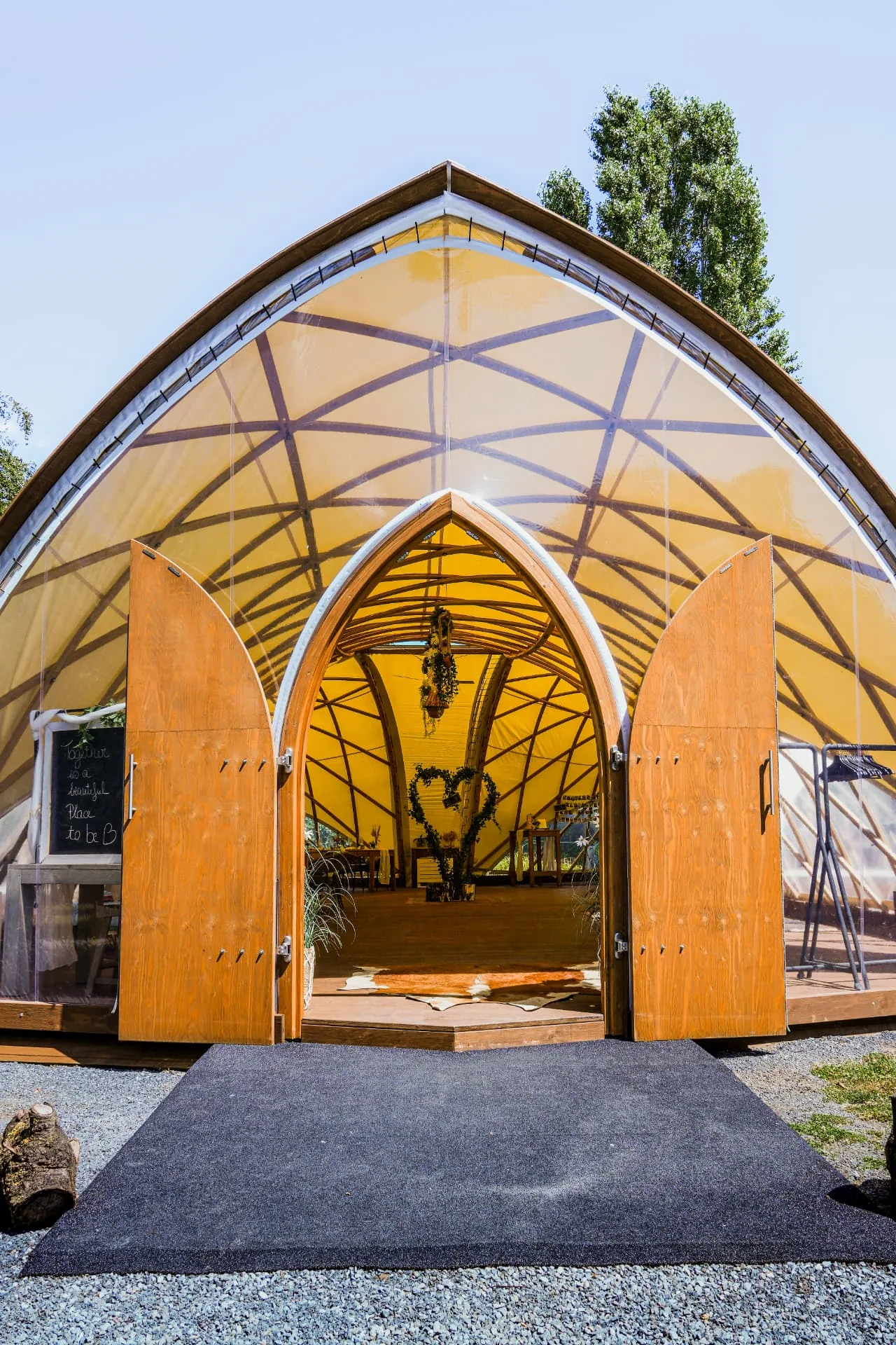 Frontaal zicht op het Strohboid-paviljoen met open houten deuren