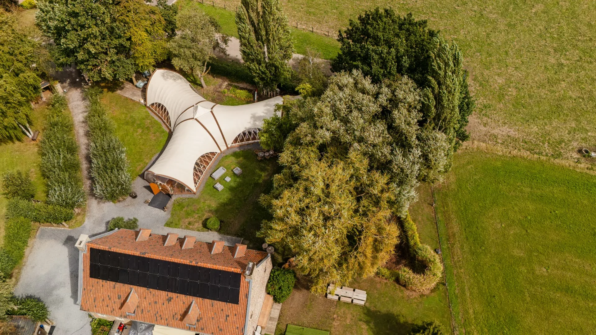 Dronebeeld van het Strohboid-paviljoen, het historische huis en de groene tuin van 50 are